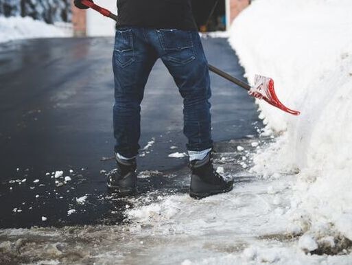Worker shoveling driveway